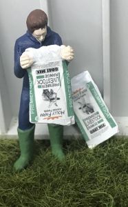 WM078M - Boer leegt een zak geitenvoer