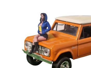 ATLAN32022_BLEU_JAUNE - Zittende vrouw met blauwe en gele capuchon
