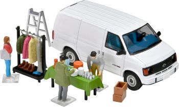 TOM333845 - Rommelmarkt met een witte Chevrolet Astro bestelwagen en accessoires.
