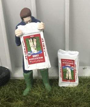 WM078F - Boer leegt een zak melkpoeder voor lammeren