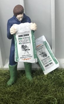 WM078M - Boer leegt een zak geitenvoer